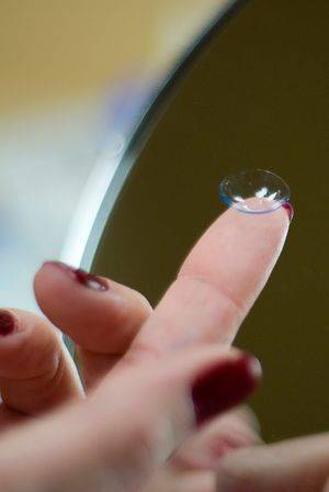 woman putting on a contact lens